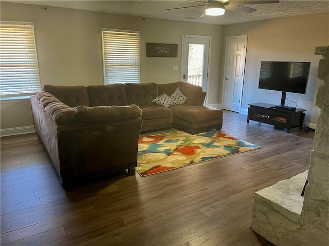 living room featuring ceiling fan and dark wood-type flooring