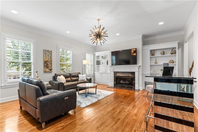 living room with ornamental molding, plenty of natural light, a fireplace, and light hardwood / wood-style flooring