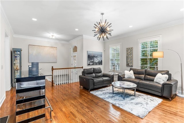 living room with a notable chandelier, light hardwood / wood-style flooring, and ornamental molding