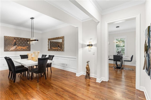 dining area featuring wood-type flooring and ornamental molding