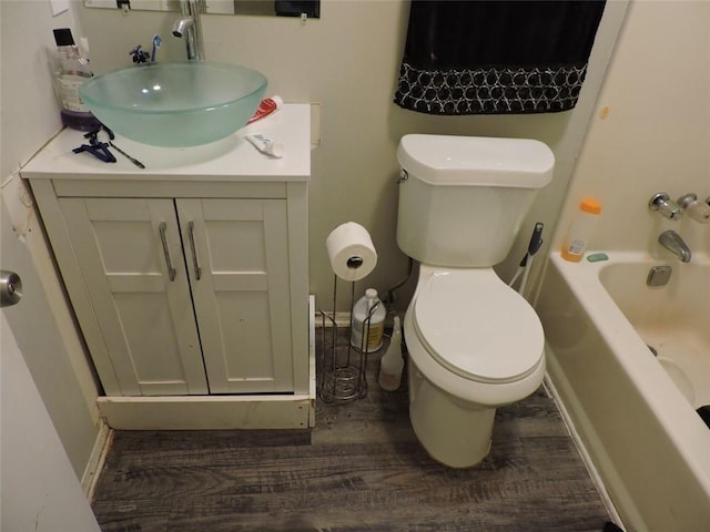 full bath featuring toilet, baseboards, wood finished floors, and vanity