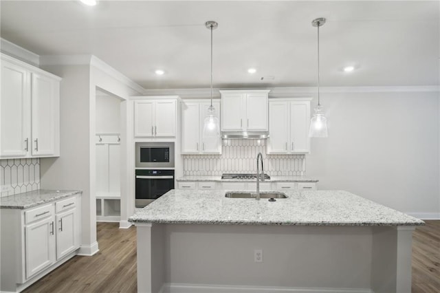 kitchen with tasteful backsplash, white cabinets, stainless steel appliances, and decorative light fixtures