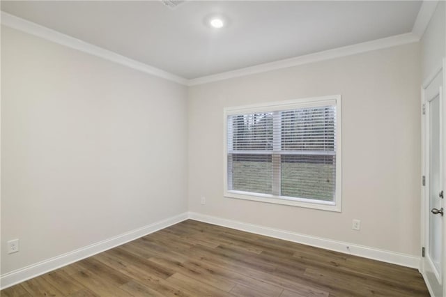 empty room featuring hardwood / wood-style flooring and ornamental molding