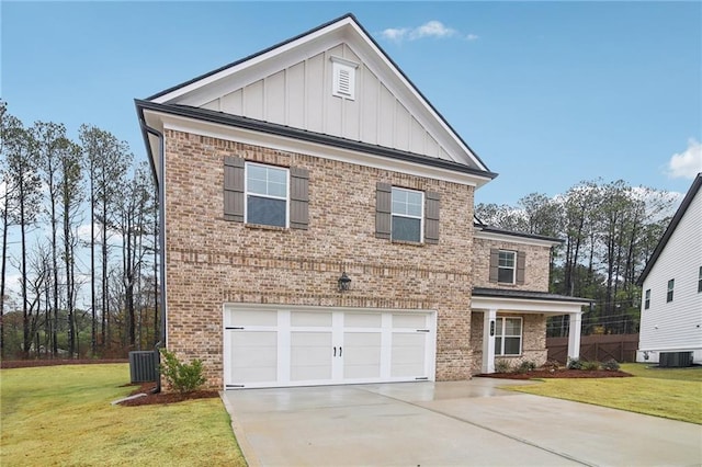 view of front of property with a front yard, central AC unit, and a garage