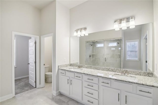 bathroom featuring vanity, toilet, and a shower with shower door