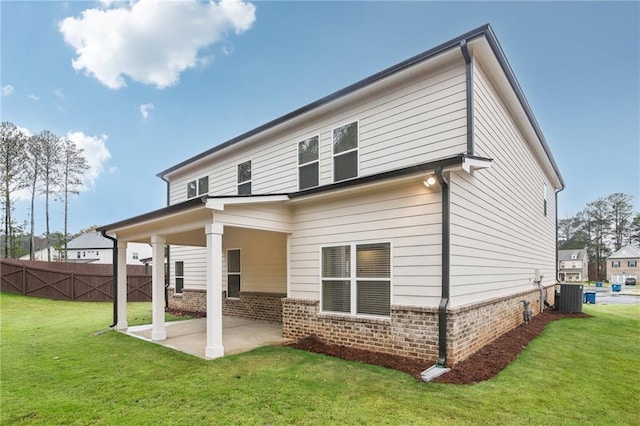 back of house featuring a lawn, central AC, and a patio