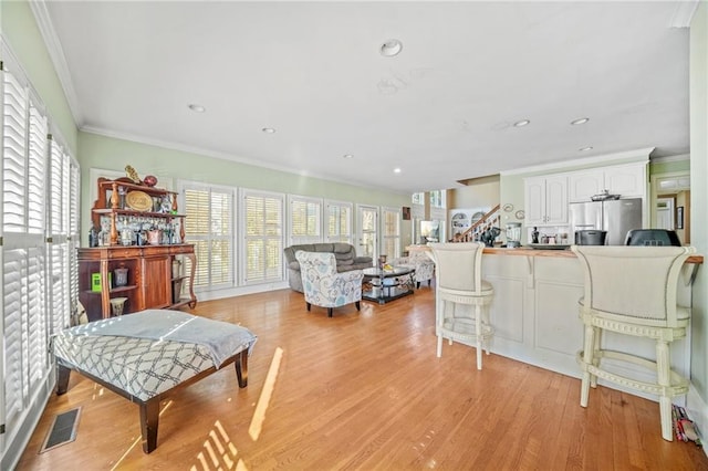 living room with light hardwood / wood-style floors and crown molding