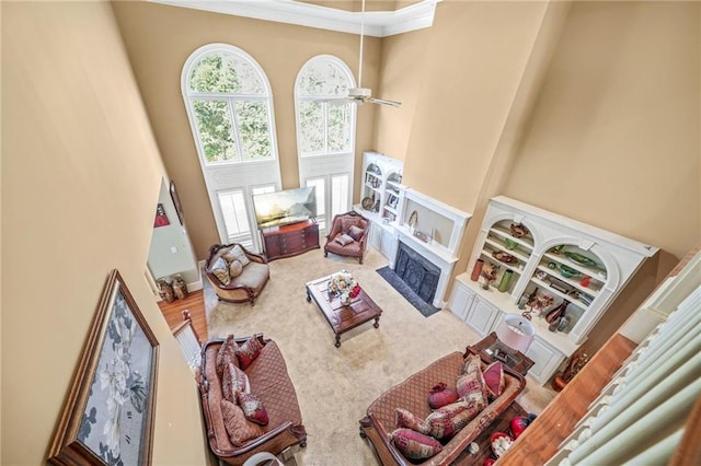 living room with a fireplace, a high ceiling, carpet floors, and ceiling fan