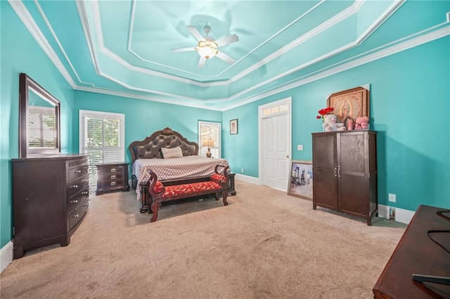 carpeted bedroom featuring a raised ceiling, ceiling fan, and ornamental molding