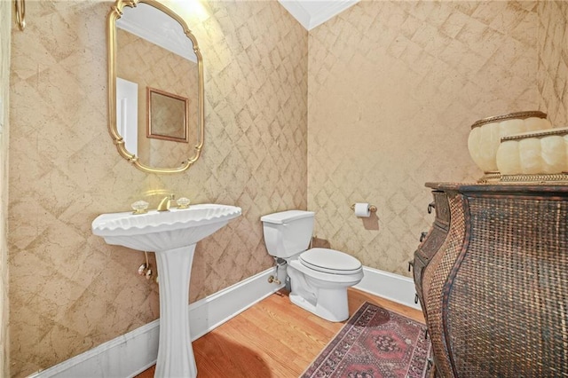 bathroom with ornamental molding, wood-type flooring, and toilet