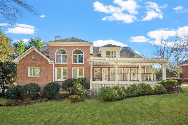 back of property featuring a pergola and a yard