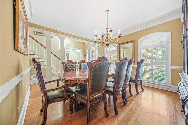 dining room with a chandelier, light wood-type flooring, and ornamental molding