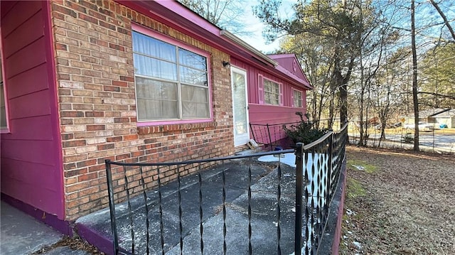 view of home's exterior with brick siding and fence