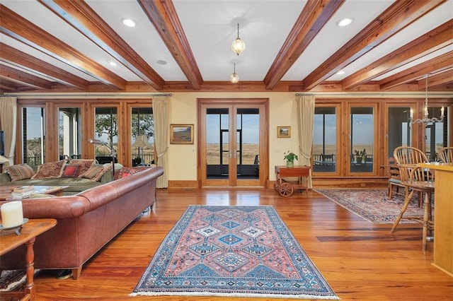 living room featuring beamed ceiling, light hardwood / wood-style floors, and french doors