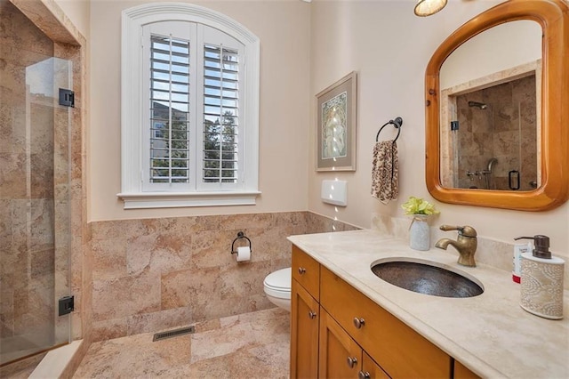 bathroom featuring tile walls, vanity, toilet, and walk in shower