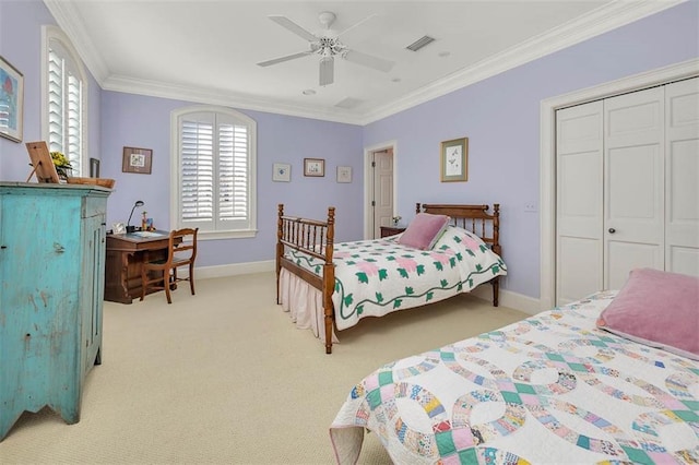 carpeted bedroom with crown molding, ceiling fan, and a closet