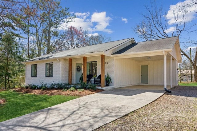 ranch-style home with brick siding, covered porch, concrete driveway, and an attached carport