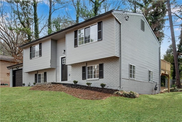 raised ranch featuring a garage and a front lawn