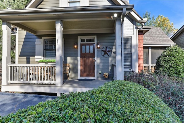 view of exterior entry featuring covered porch