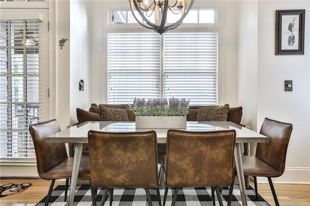 dining area with hardwood / wood-style floors and a notable chandelier