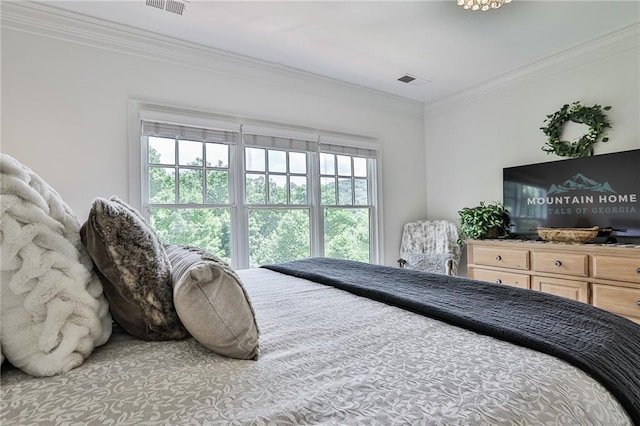 bedroom with ornamental molding and multiple windows