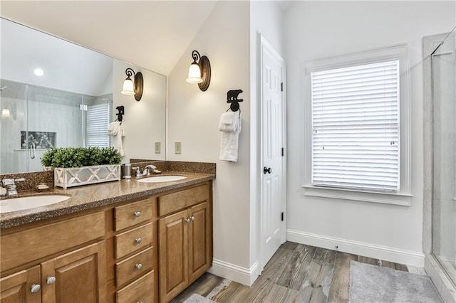 bathroom with hardwood / wood-style floors, vanity, a shower with door, and vaulted ceiling