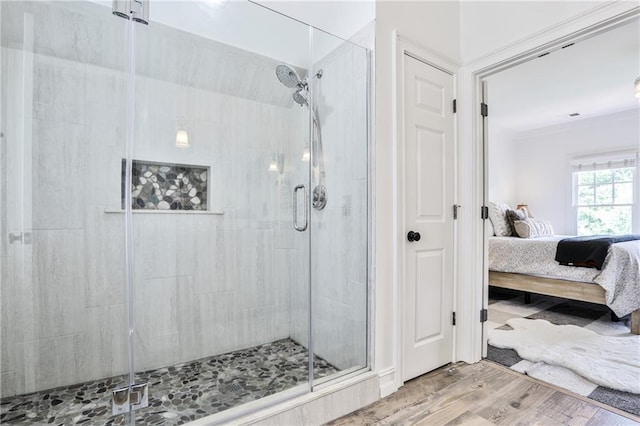 bathroom featuring hardwood / wood-style flooring, walk in shower, and ornamental molding