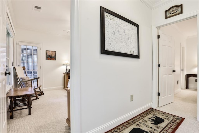 hallway featuring crown molding and light colored carpet