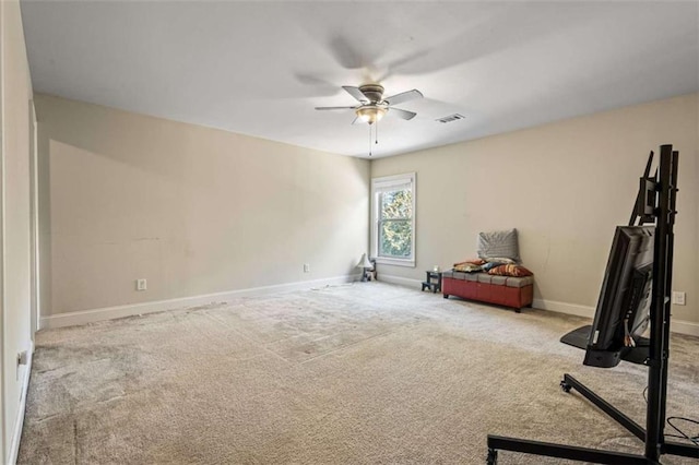 exercise area featuring light carpet and ceiling fan