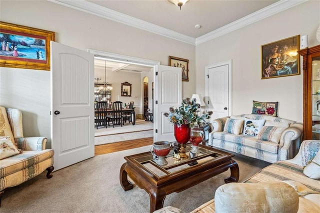 carpeted living room featuring ornamental molding and a chandelier