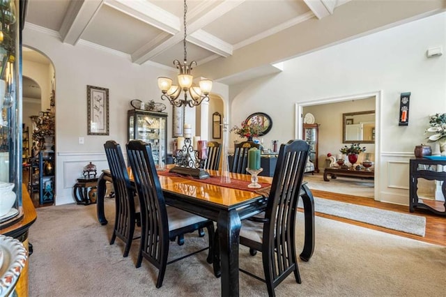 carpeted dining room with an inviting chandelier, beam ceiling, coffered ceiling, and crown molding