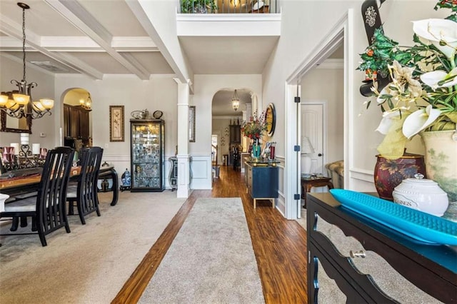 entryway featuring beam ceiling, coffered ceiling, dark hardwood / wood-style floors, and an inviting chandelier