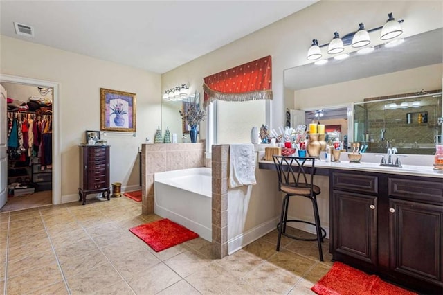 bathroom with tile patterned floors, vanity, and separate shower and tub