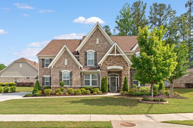 view of front of home featuring a front lawn, stone siding, and brick siding