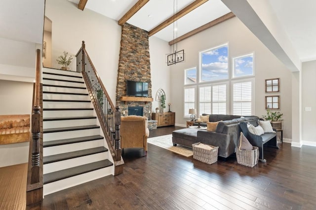 living area with a high ceiling, beamed ceiling, a fireplace, stairway, and wood-type flooring