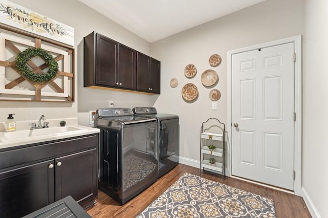 laundry room featuring washer and clothes dryer, wood finished floors, cabinet space, and baseboards