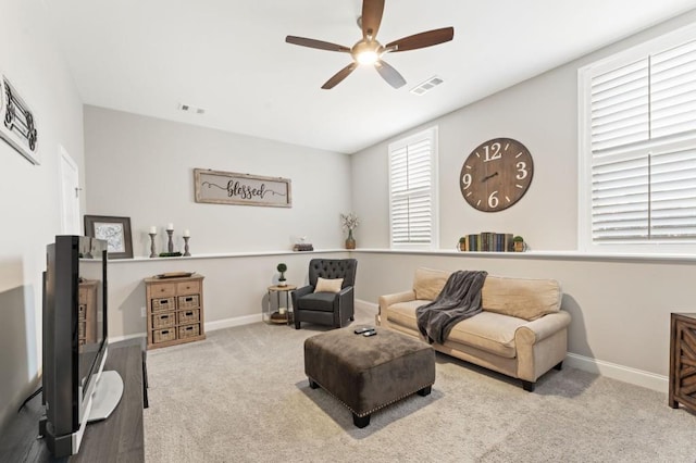 carpeted living room with a ceiling fan and baseboards