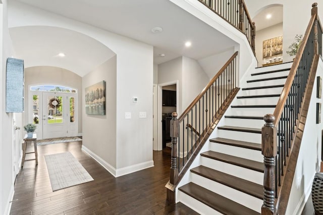 entrance foyer with arched walkways, baseboards, stairs, wood finished floors, and recessed lighting