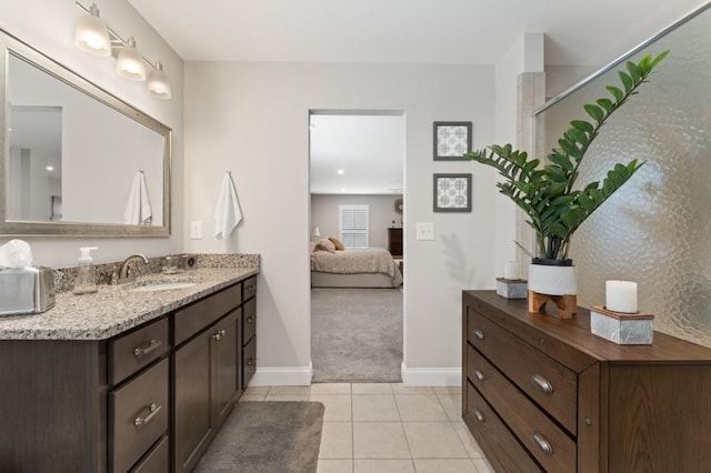 bathroom with connected bathroom, baseboards, tile patterned flooring, and vanity