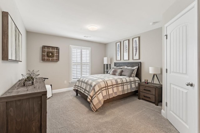 bedroom with light colored carpet and baseboards