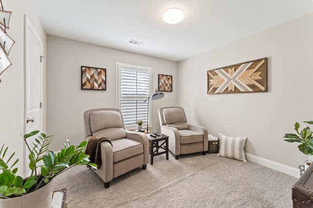 living area featuring light carpet and baseboards