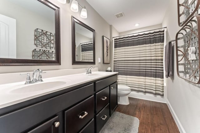bathroom with wood finished floors, double vanity, toilet, baseboards, and curtained shower