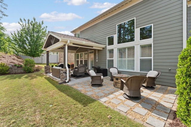 rear view of house featuring an outdoor living space with a fire pit and a patio area