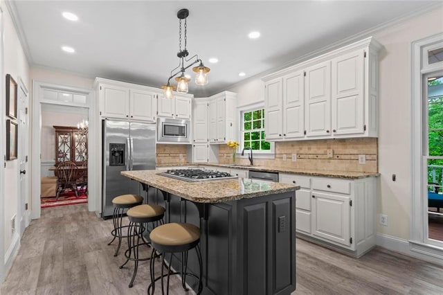 121 Clipper Bay Dr, Alpharetta, GA 30005 - kitchen with stainless steel appliances, white cabinets, a center island, crown molding, and light wood-style flooring