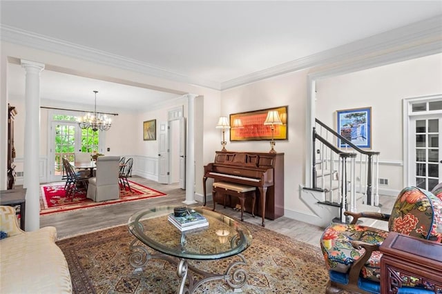 121 Clipper Bay Dr, Alpharetta, GA 30005 - living area featuring wood finished floors, a chandelier, ornate columns, crown molding, and stairs