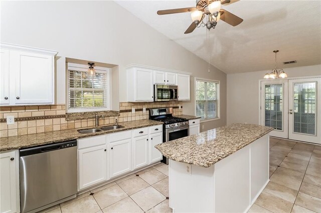 kitchen featuring white cabinetry, a center island, stainless steel appliances, and vaulted ceiling