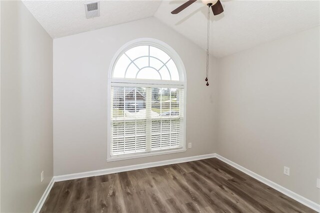 spare room featuring a textured ceiling, ceiling fan, dark wood-type flooring, and lofted ceiling