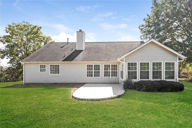 rear view of property with a lawn and a patio area