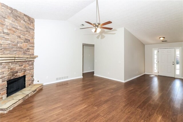 unfurnished living room featuring a fireplace, dark hardwood / wood-style flooring, vaulted ceiling, and ceiling fan