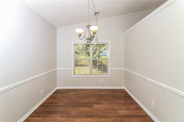 unfurnished dining area with a chandelier, dark hardwood / wood-style flooring, a textured ceiling, and vaulted ceiling